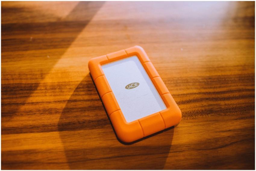 Close-up of an orange portable hard drive on a woo