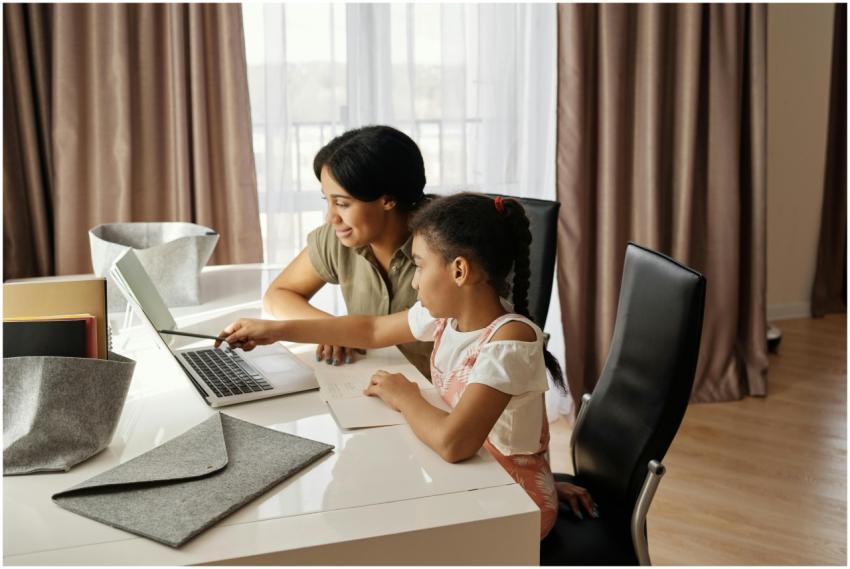 A mother assisting her daughter with online learni