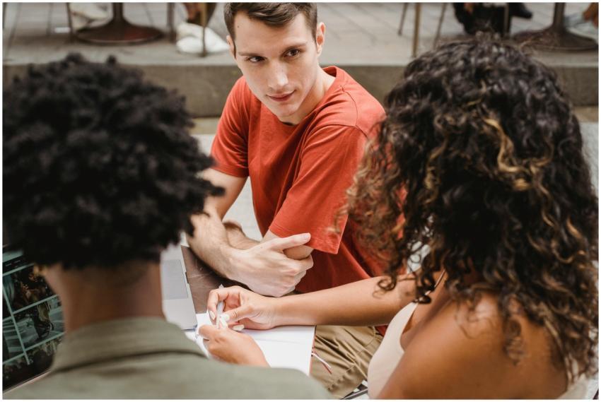 Young adults discussing a project outdoors with a