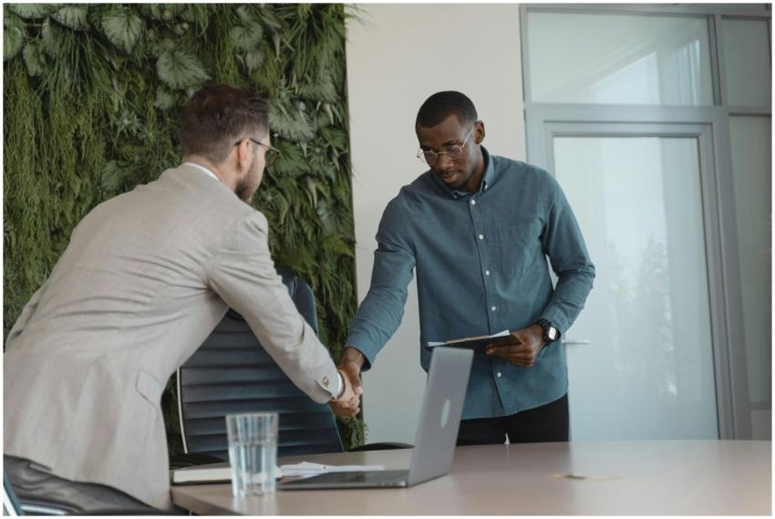 Two businessmen shaking hands in a modern office s