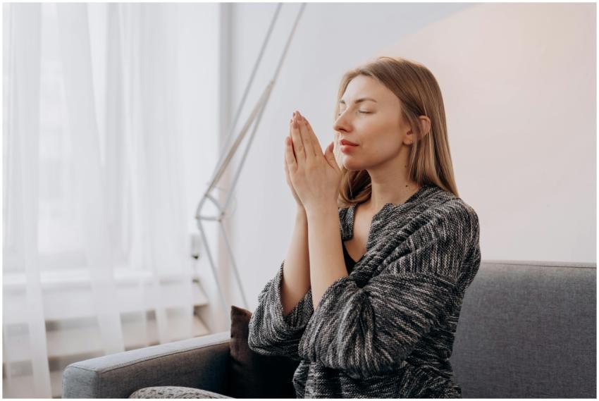 A woman meditates peacefully indoors, seeking rela