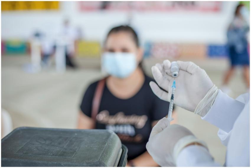 Healthcare worker prepares vaccine for patient in