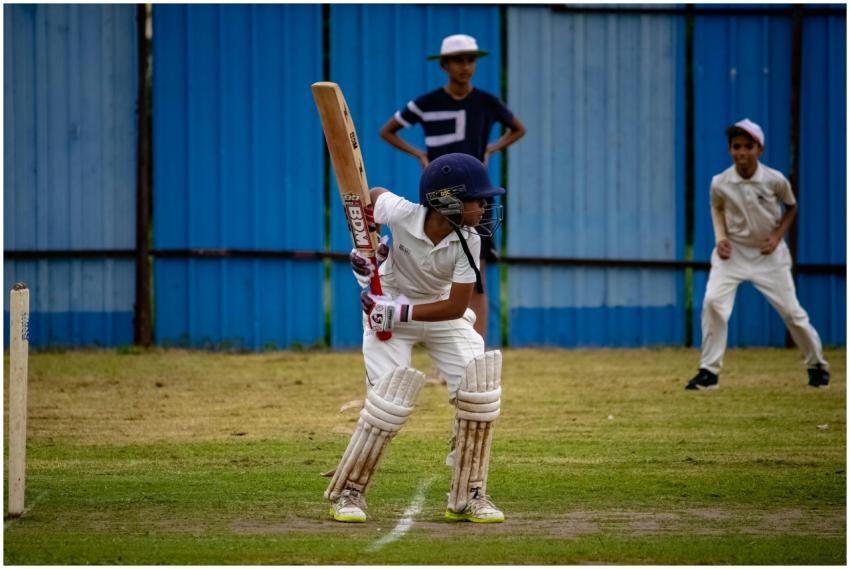 A young cricketer prepares to bat during a match i