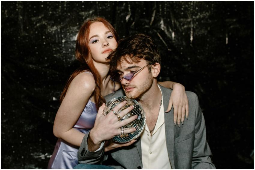 Trendy couple striking a fashionable pose with a d