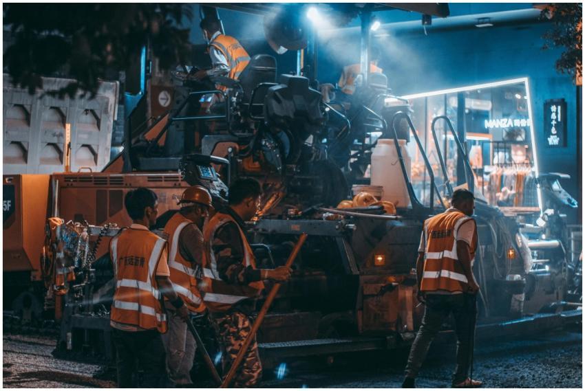 Road construction crew at work with machinery and