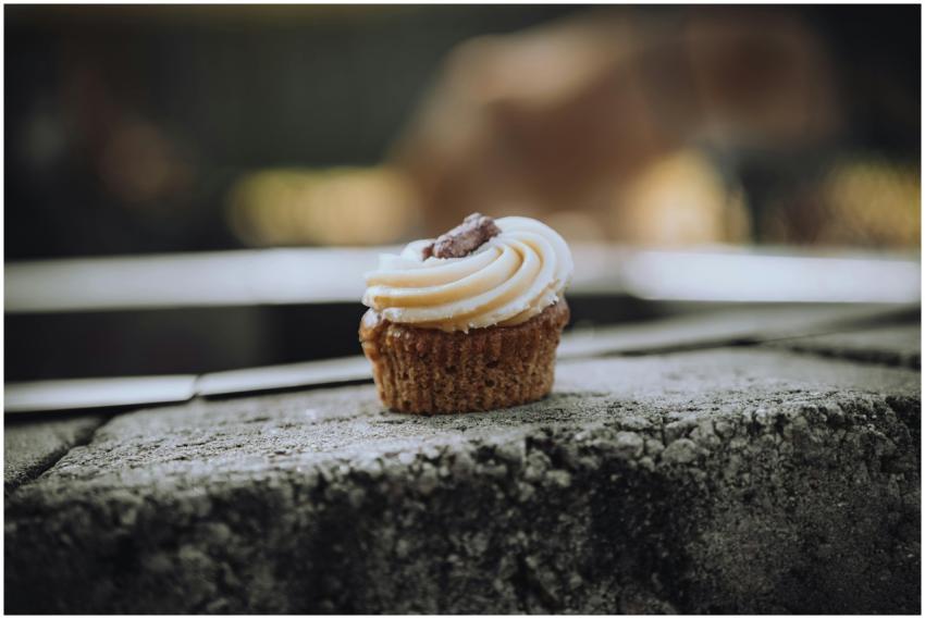 Tasty cupcake with creamy frosting on a concrete s