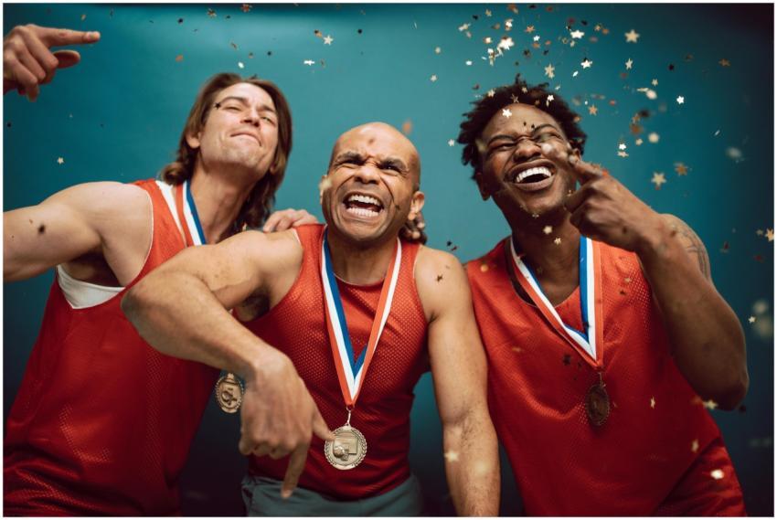 Three diverse athletes celebrate their victory wit