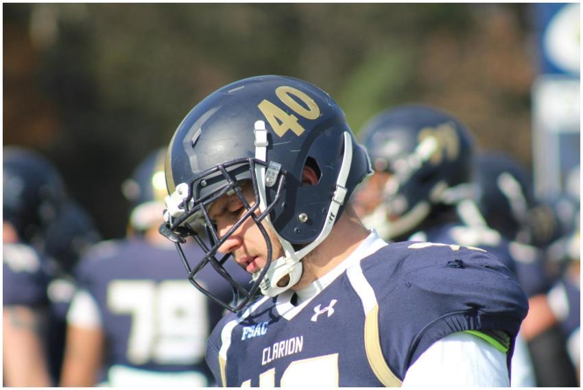 Football player in helmet and uniform focused duri