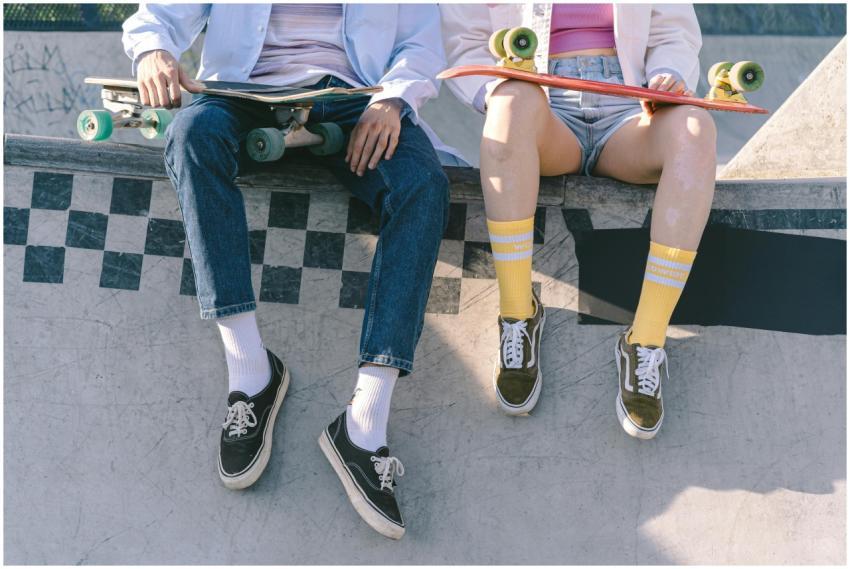 Two skateboarders sitting with skateboards at a pa