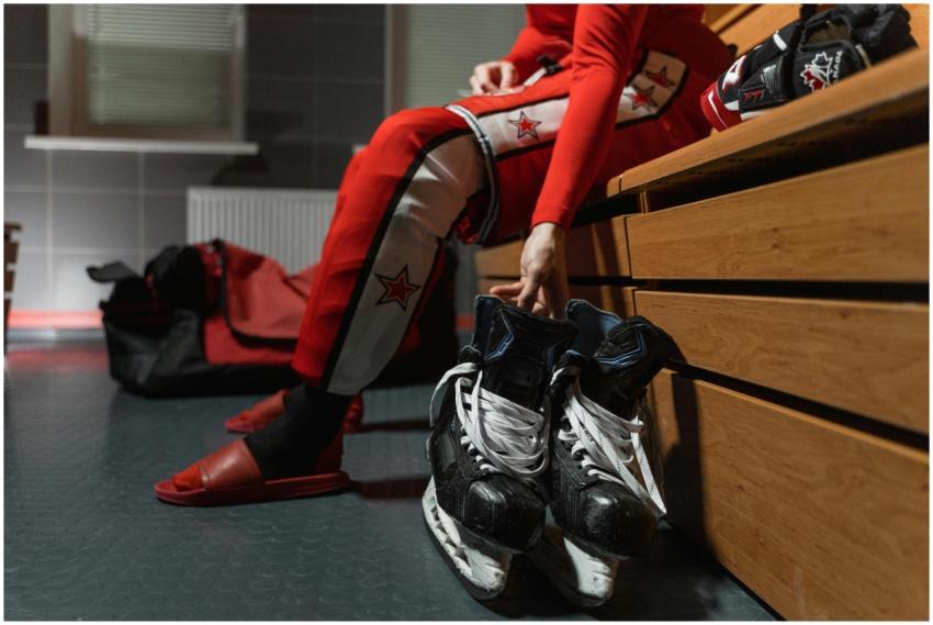 Ice hockey player sitting on bench ready to put on