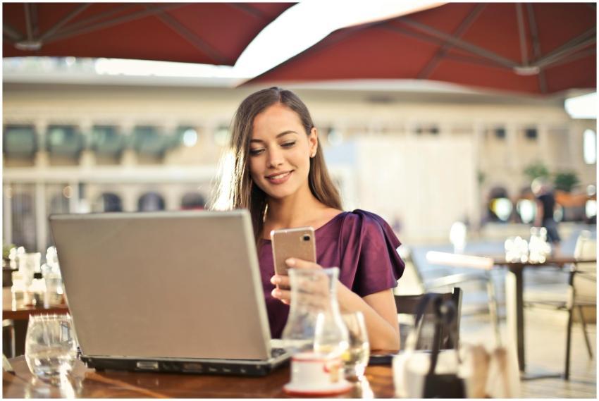 Woman enjoying remote work at a café, using a lapt
