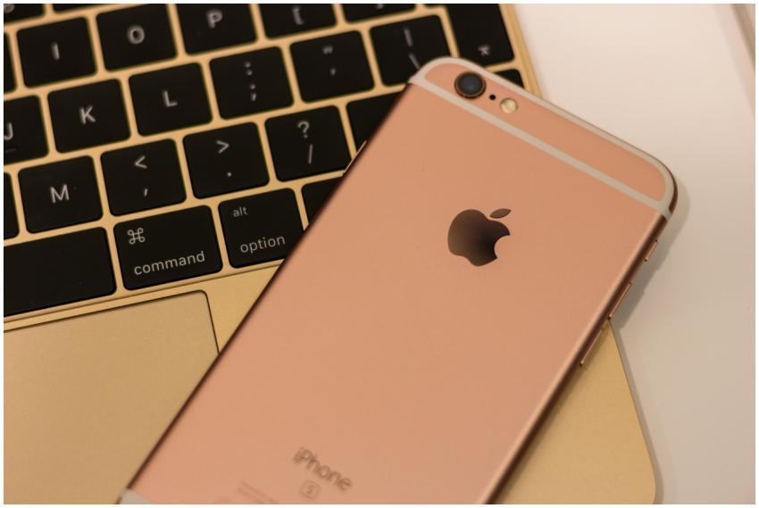 Close-up of a rose gold iPhone 6s placed on a MacB