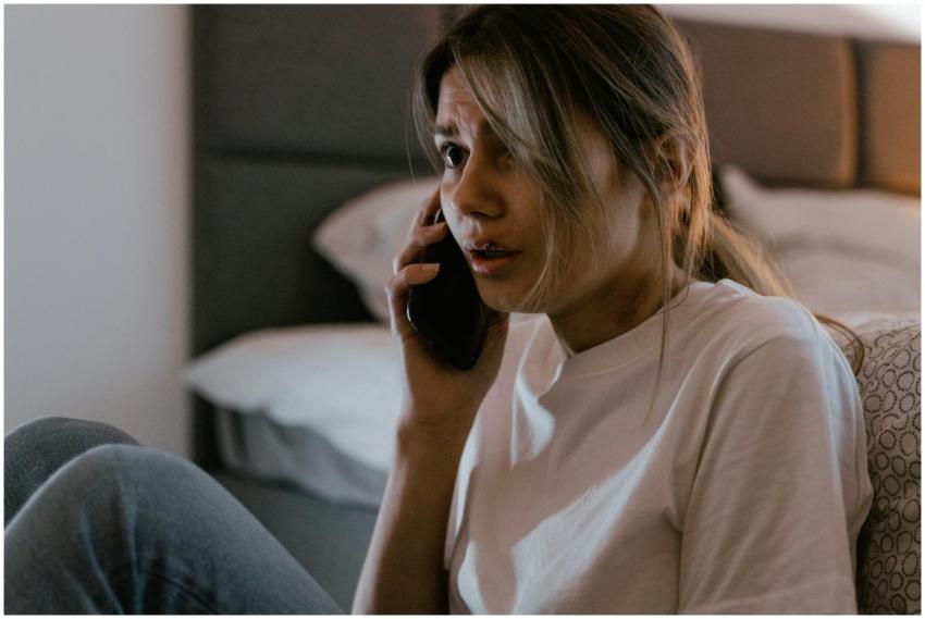 A worried woman in a white shirt making a distress