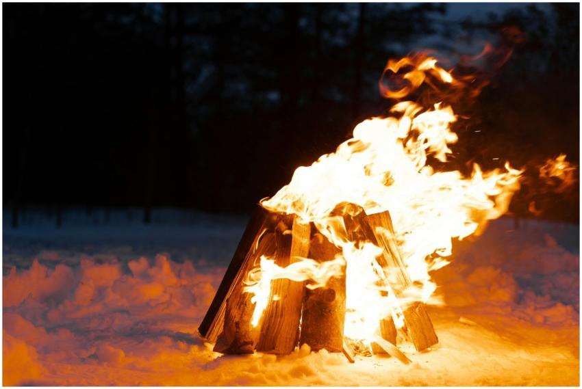 Warm campfire burning brightly in a snowy winter l
