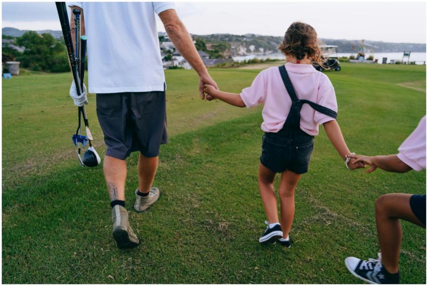 Father and daughter holding hands while walking on