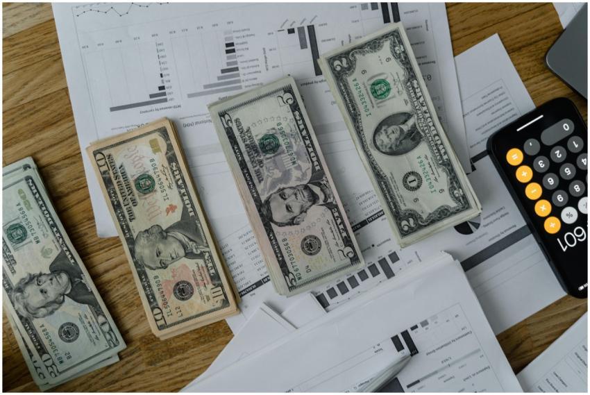 A workspace setup featuring cash, documents, and a