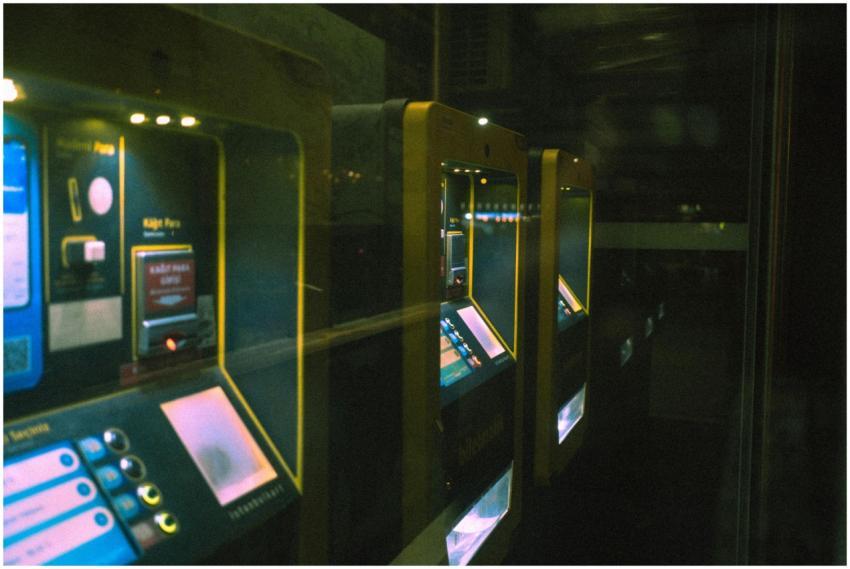 Row of illuminated ticket machines in a dark setti