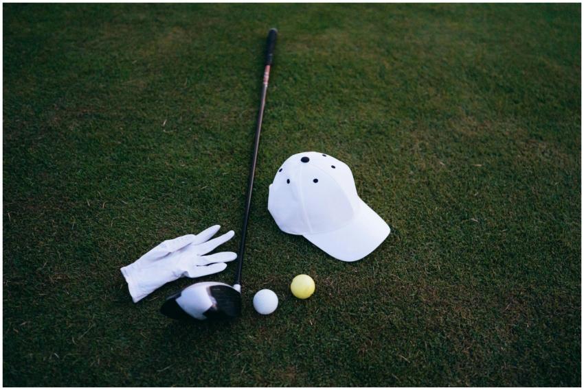 Close-up of golf club, balls, glove, and cap place