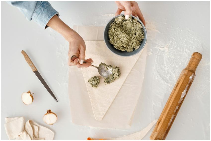 Woman preparing dough with herb filling for homema