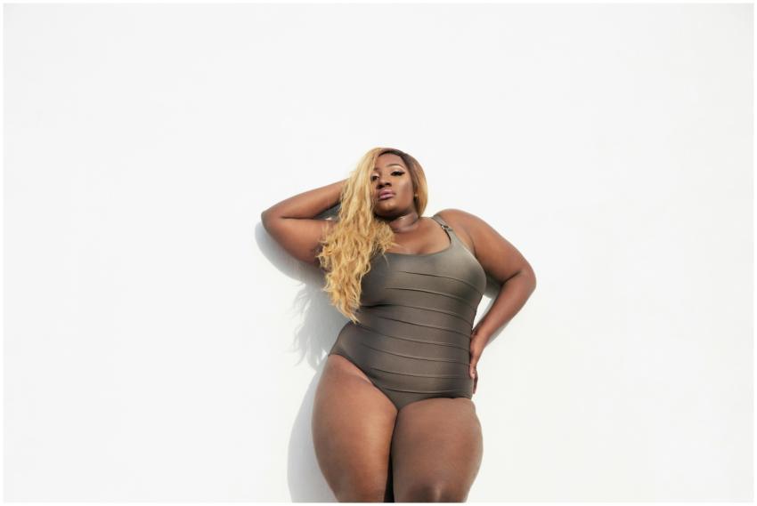 A confident black woman in a swimsuit posing again