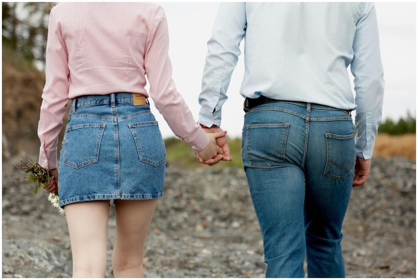 A couple walking hand in hand wearing denim. The s
