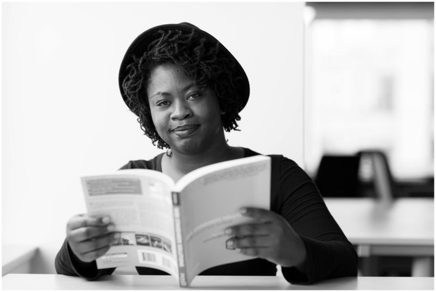 Smiling black woman reading a book in a monochrome
