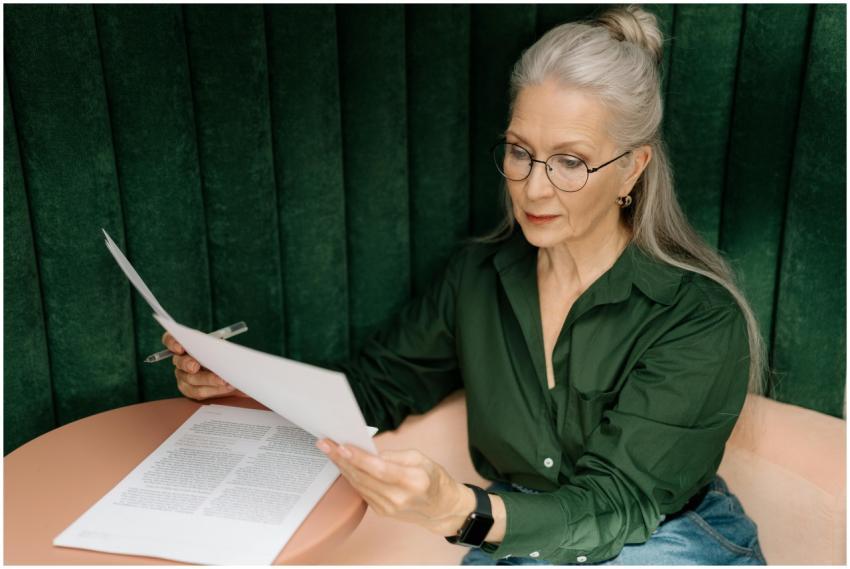 Senior woman wearing glasses, reading documents at