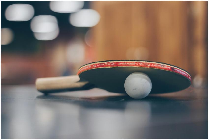 Close-up of a ping pong paddle and ball on a table