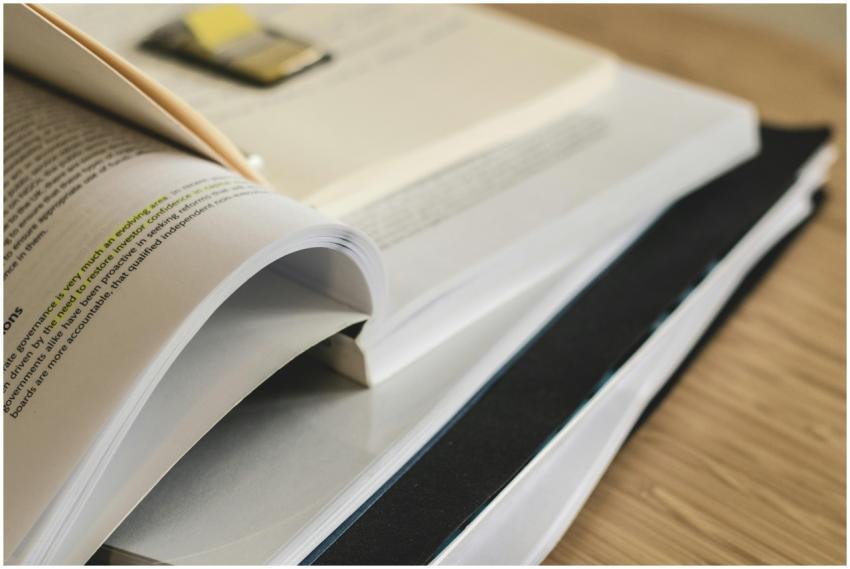 A pile of open books on a table, ideal for study a