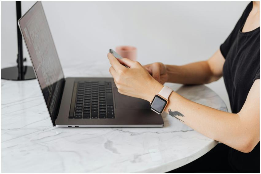 Adult using smartphone and laptop simultaneously a