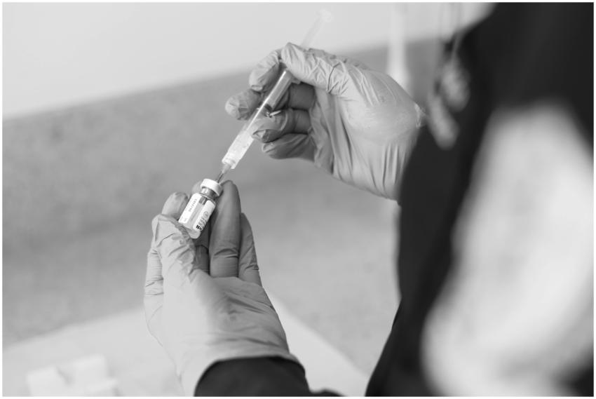 A healthcare worker prepares a syringe with medica