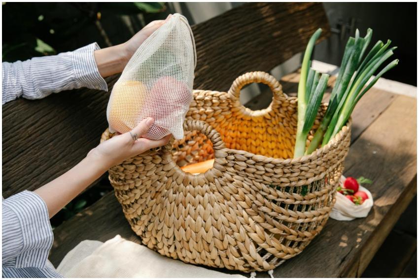 Crop anonymous female placing fresh ripe capsicums