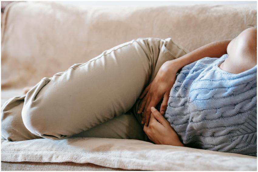 Crop faceless female in casual wear lying on sofa