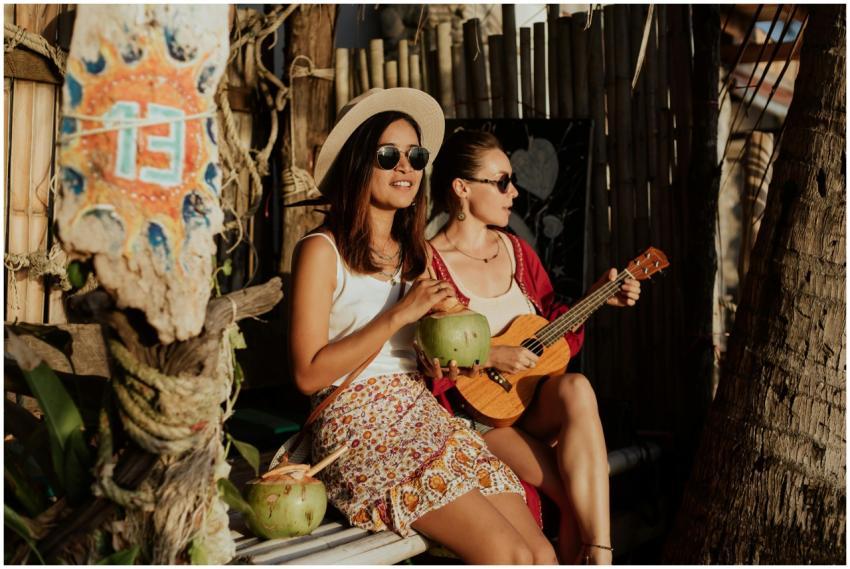Women relaxing with coconut drinks, enjoying music