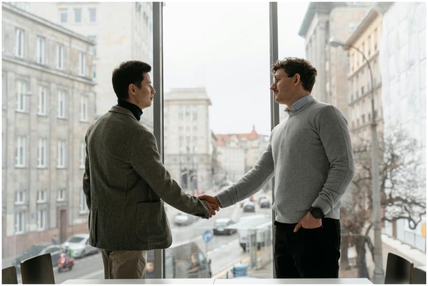 Two businessmen shaking hands in an urban office w