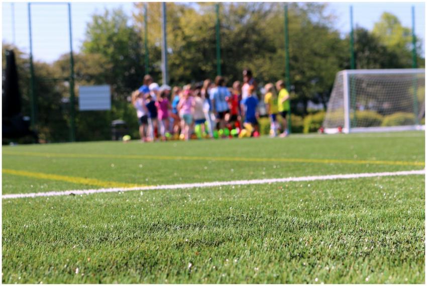 A group of children practicing soccer on a lush gr
