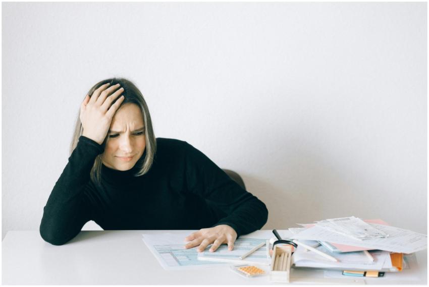 Woman in black sweater stressed with financial pap