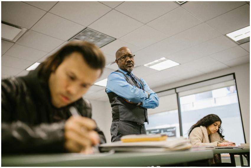 A professor supervises students during an exam, en