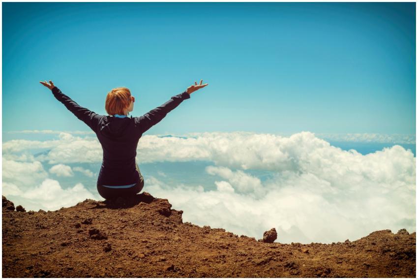 A woman enjoys a scenic view atop a cliff in Kula,