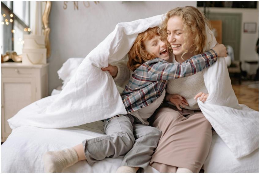 A mother and daughter share a joyful moment, wrapp