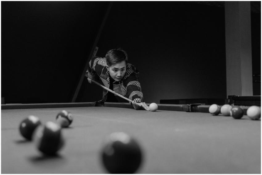 Black and white photo of a man with a cue stick fo