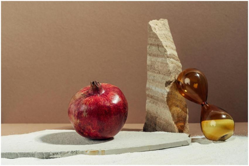Artistic composition featuring a pomegranate, hour