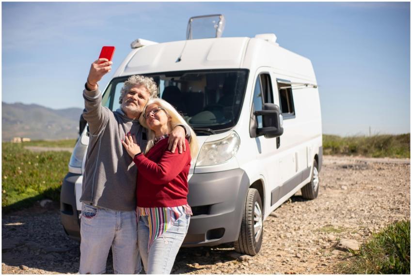 A senior couple taking a selfie with their RV in P