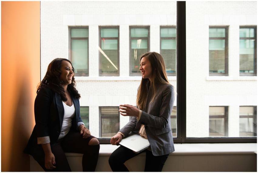 Two businesswomen enjoying a conversation by a lar