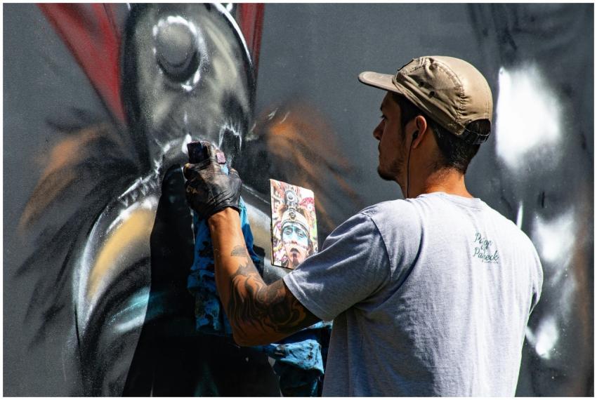 A street artist in action painting vibrant graffit