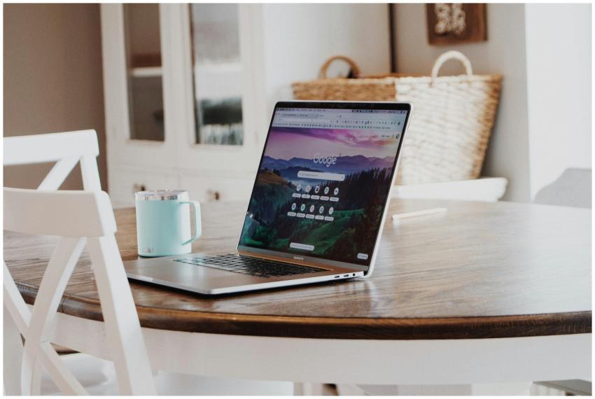 A sleek laptop on a wooden table with a mug, exemp