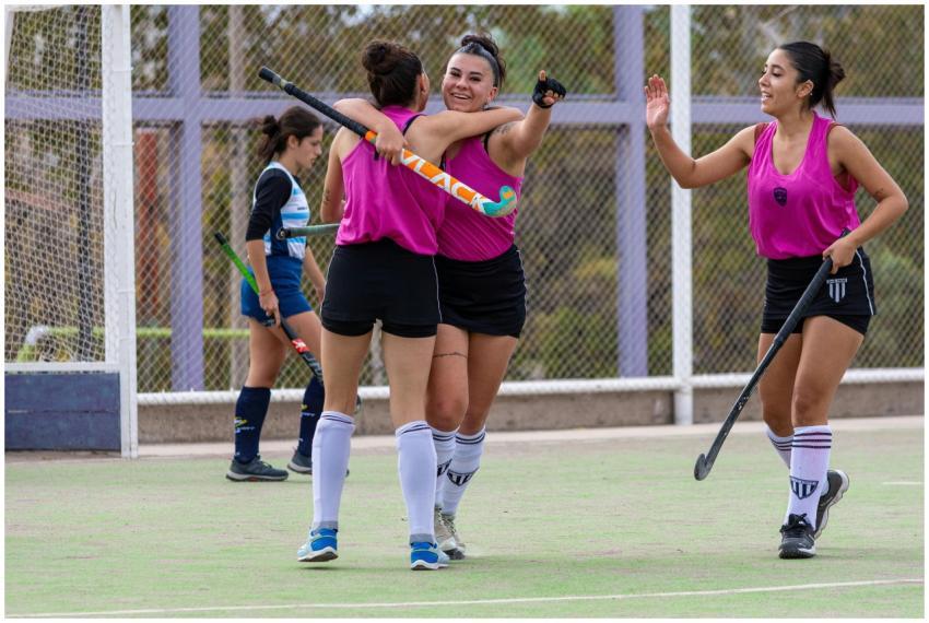 Female field hockey players celebrating a successf