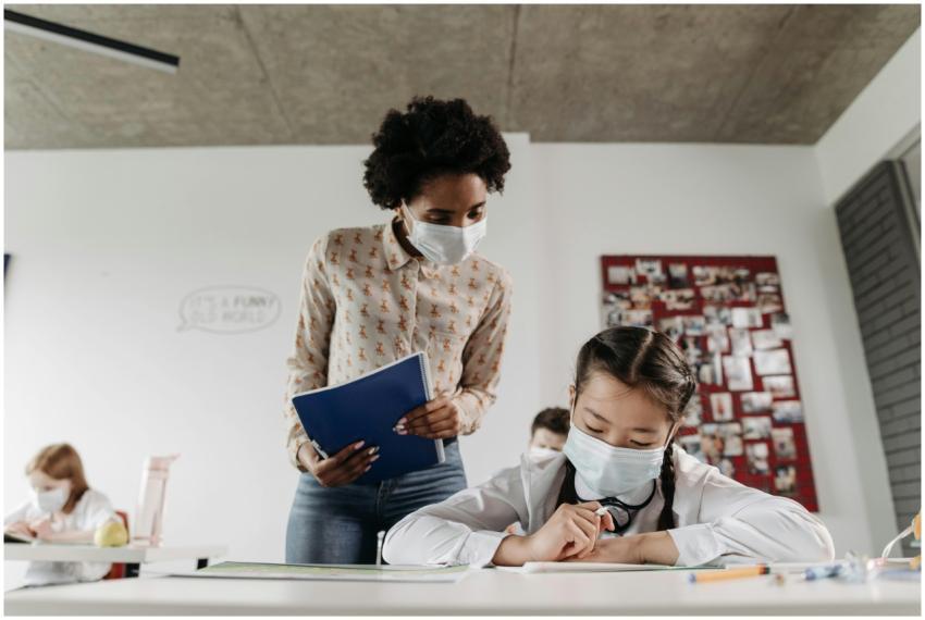 Teacher assisting student in classroom during pand