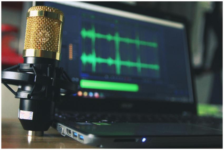 Close-up of a golden microphone and laptop used fo