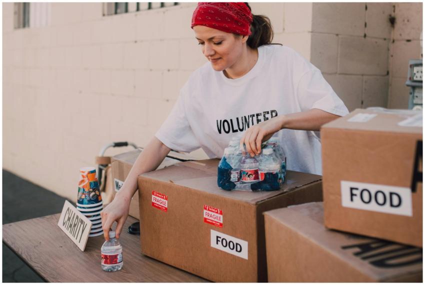Woman volunteer sorting food and water for charity